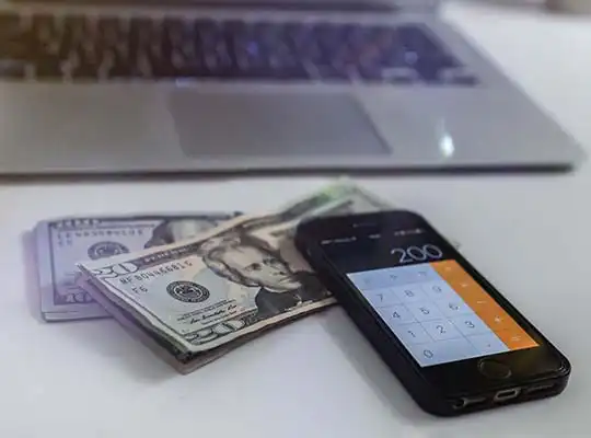 Money in front of a computer. Lack of money is leading to a mental health treatment gap.